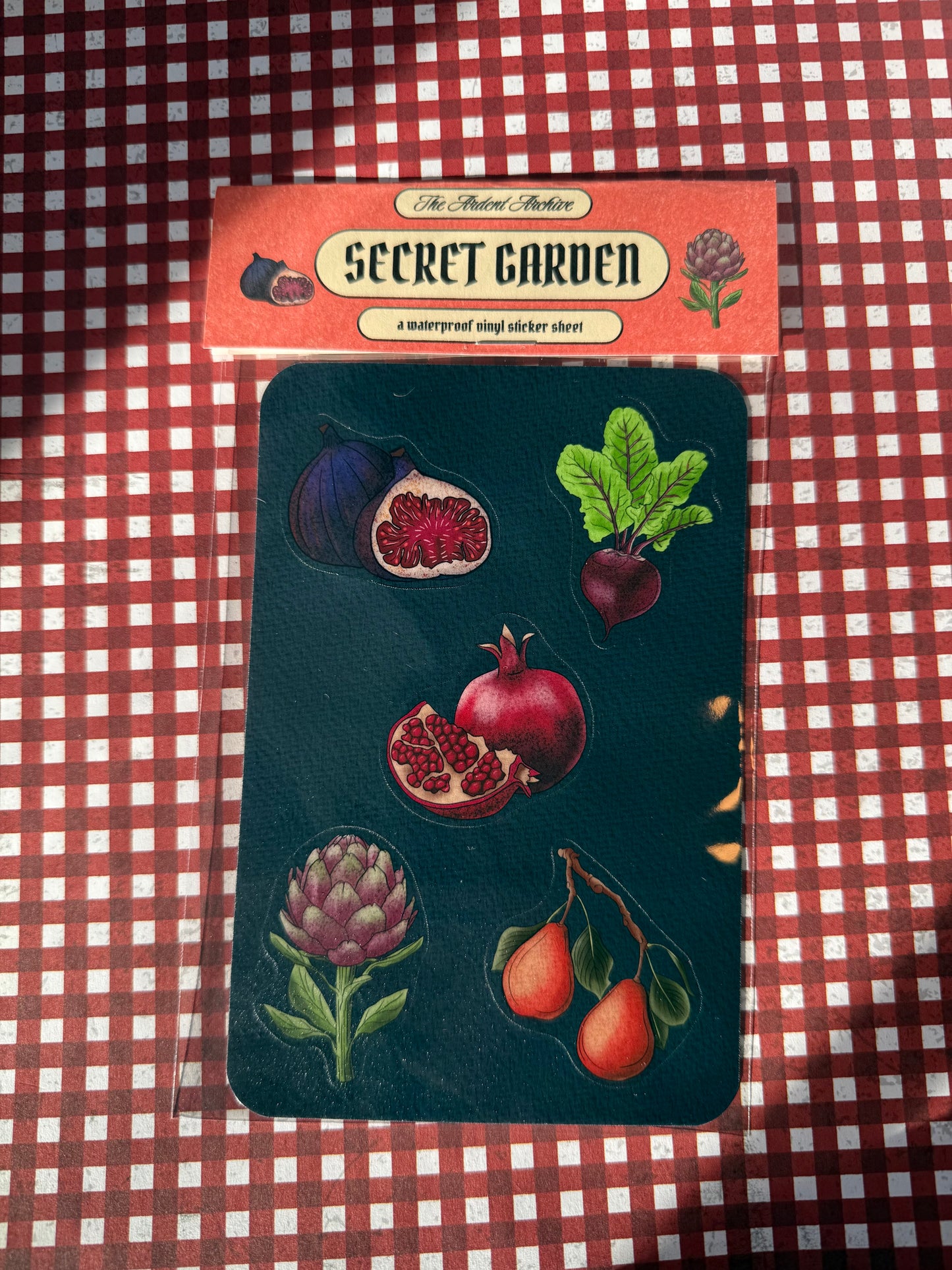 Sticker sheet with fruit and plant designs on a checkered fabric background