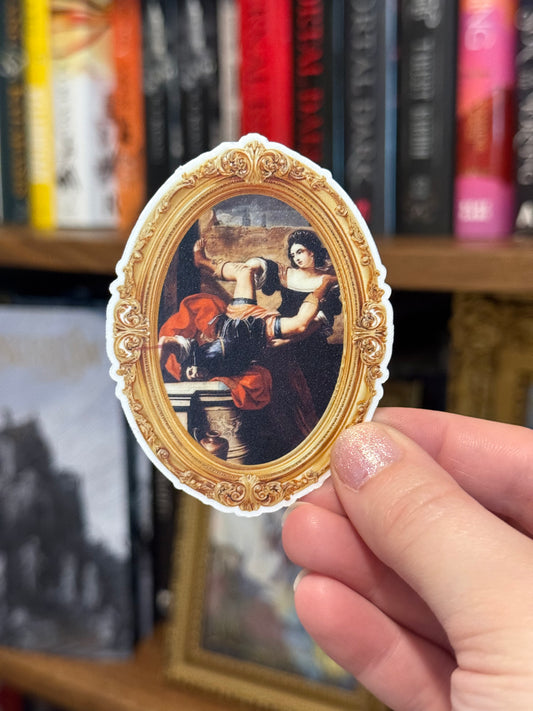 Hand holding a decorative sticker with classical painting design in front of a bookshelf.