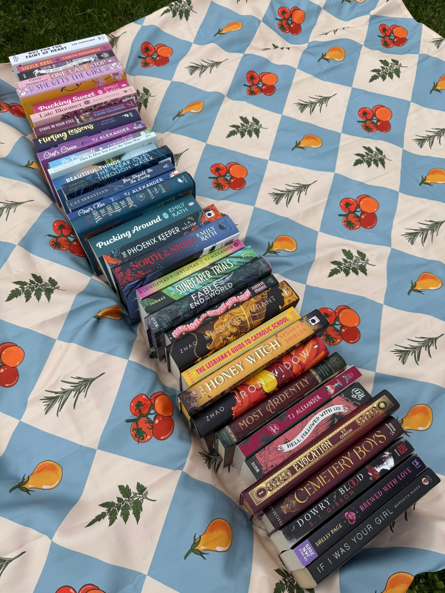 Stack of books on a patterned blanket with fruits and leaves