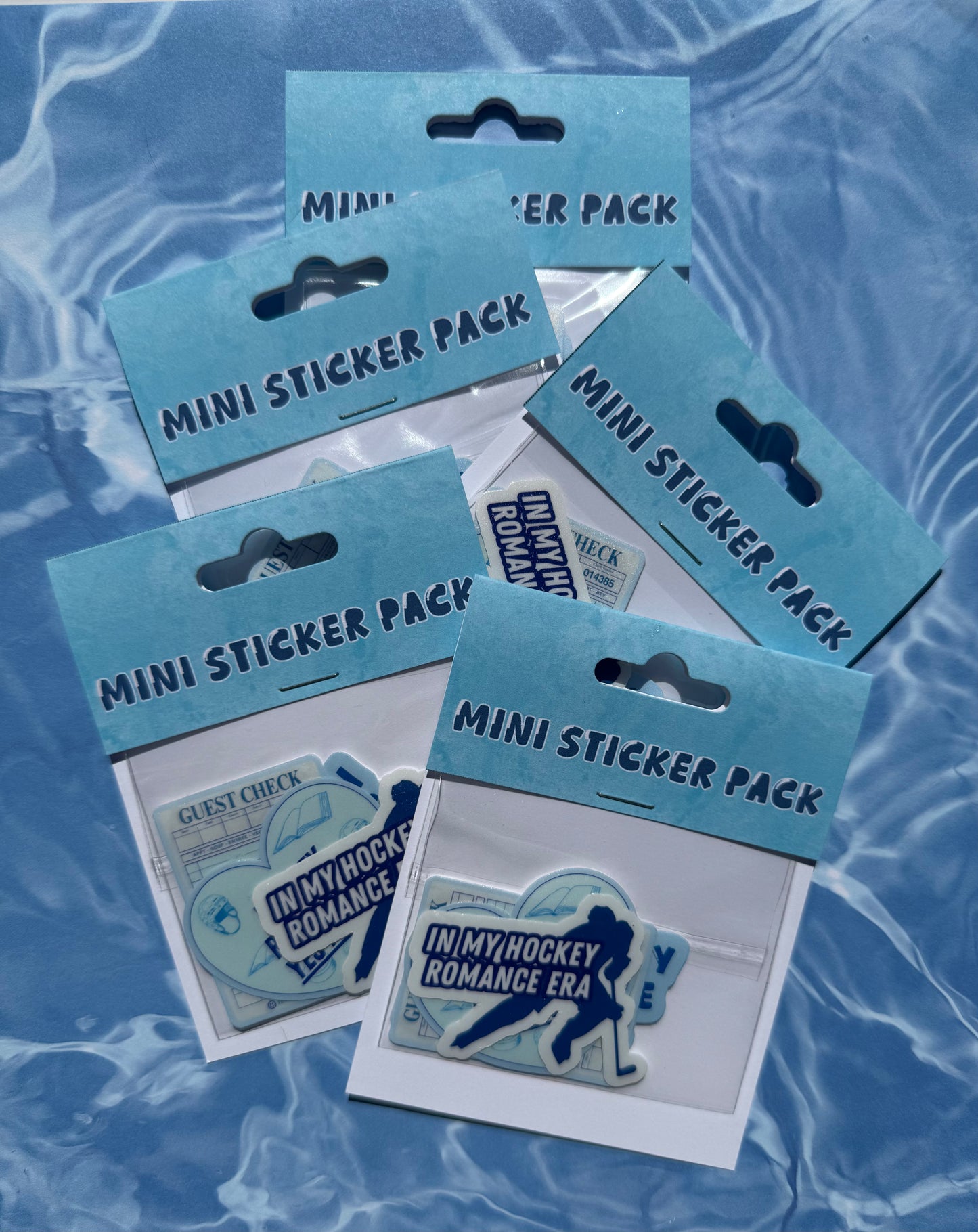 Mini Sticker Packs in paper and plastic packages on blue background
