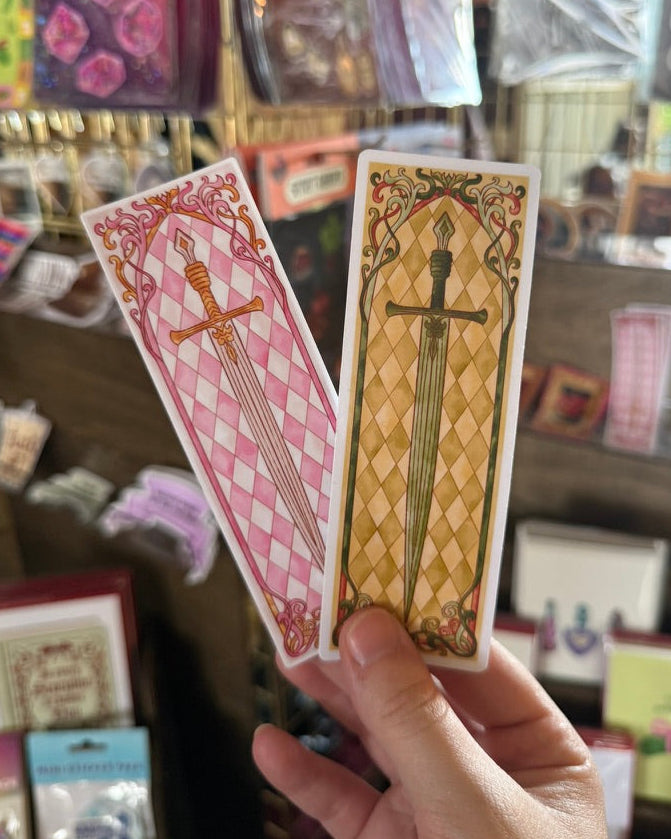 Hand holding two sword stickers