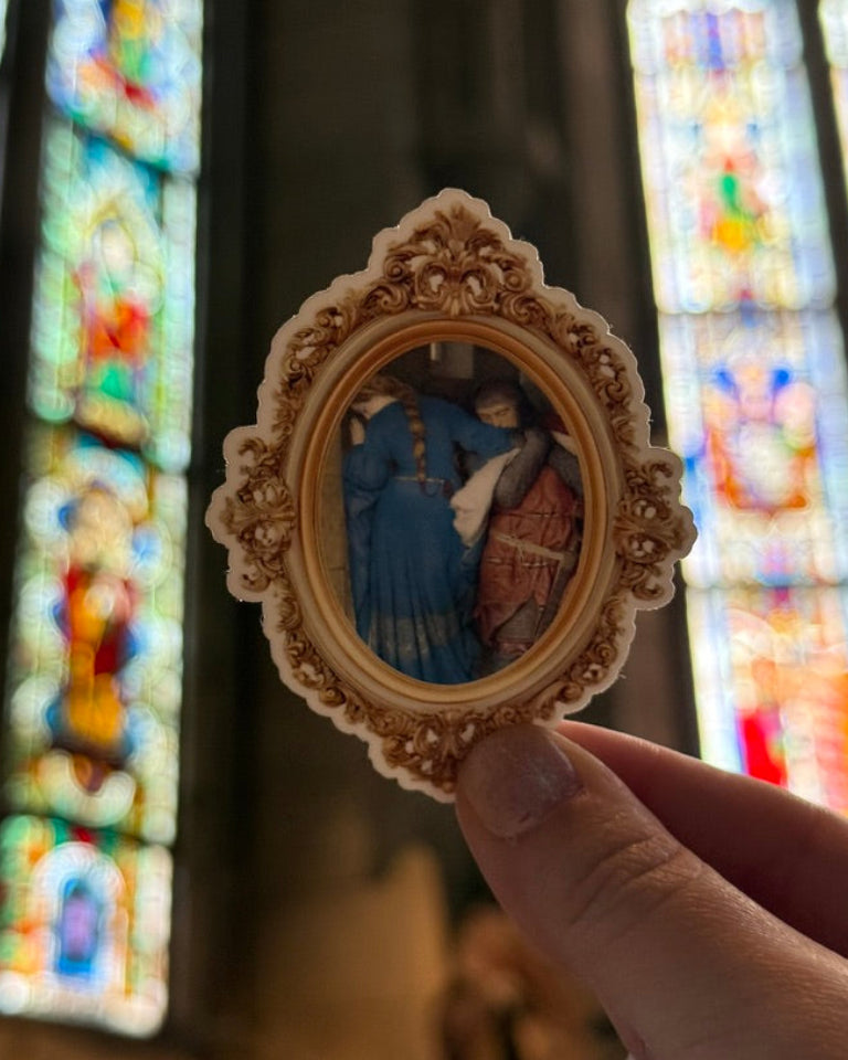 Decorative religious pendant held in front of stained glass windows
