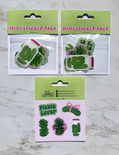 Two mini sticker packs with pickle-themed designs on a marble surface.