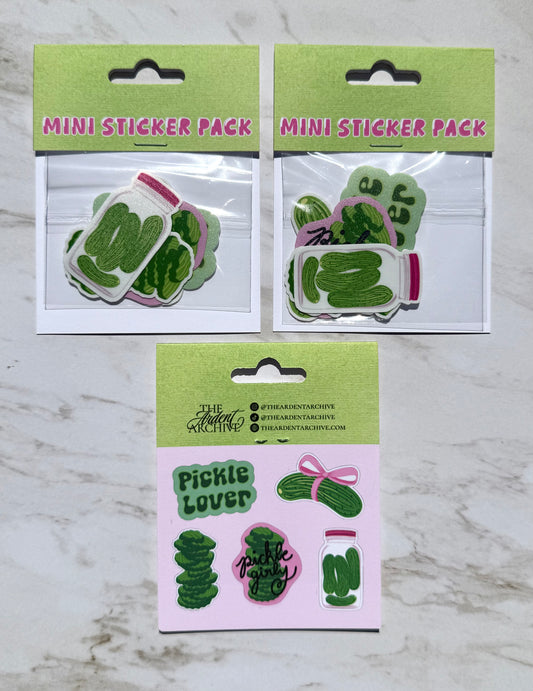 Two mini sticker packs with pickle-themed designs on a marble surface.