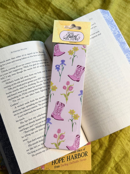 Bookmark with pink boots and flowers on a book, with 'The Ardent Archive' label.