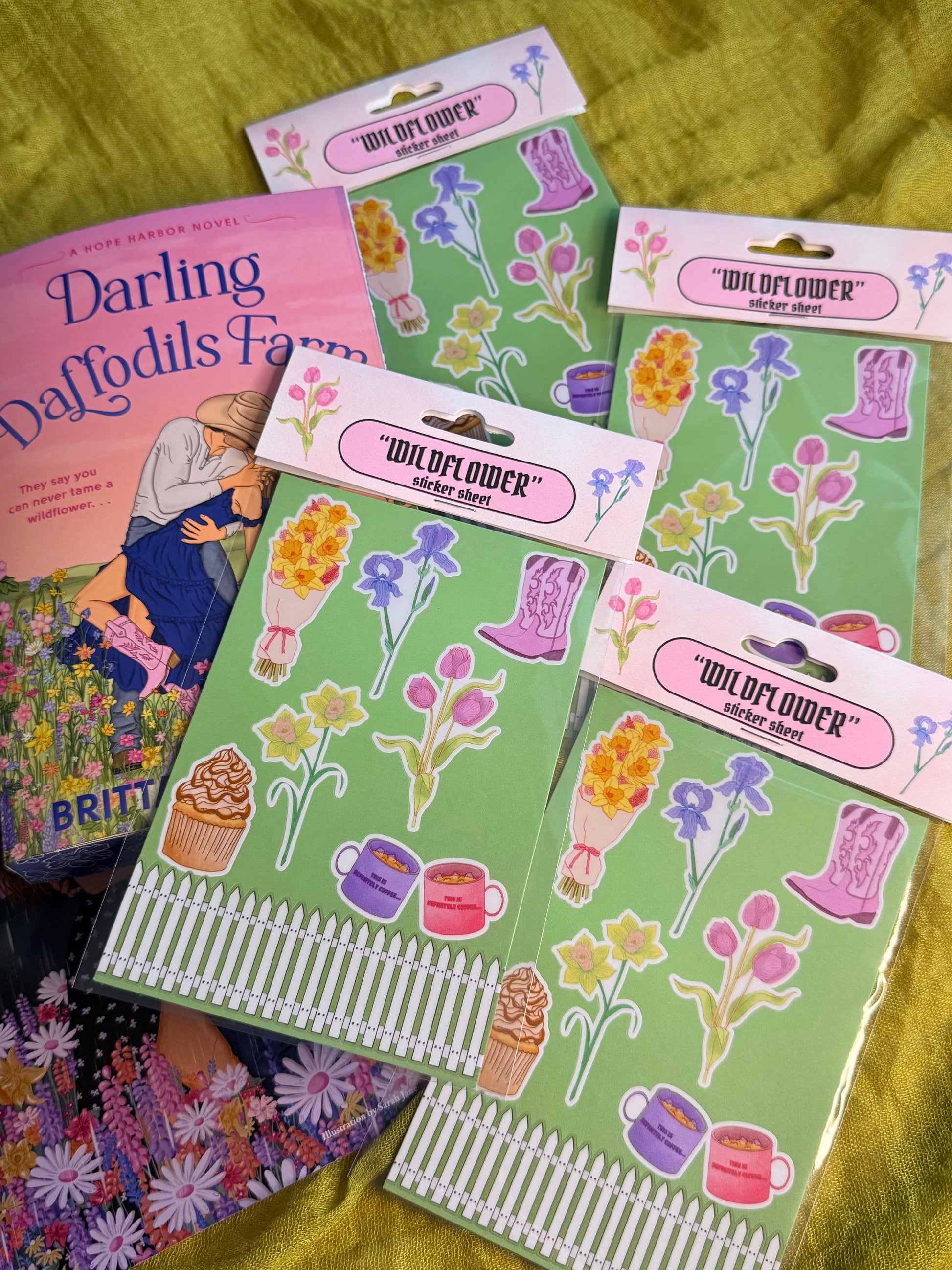 Sticker sheets with floral and boot designs on a green fabric background