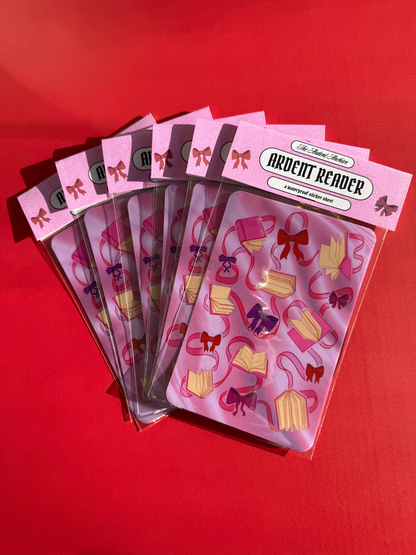 Sticker sheet of decorative ribbons and bows on a pink card with a red background.
