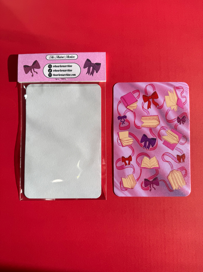 Sticker sheet of decorative ribbons and bows on a pink card with a red background.