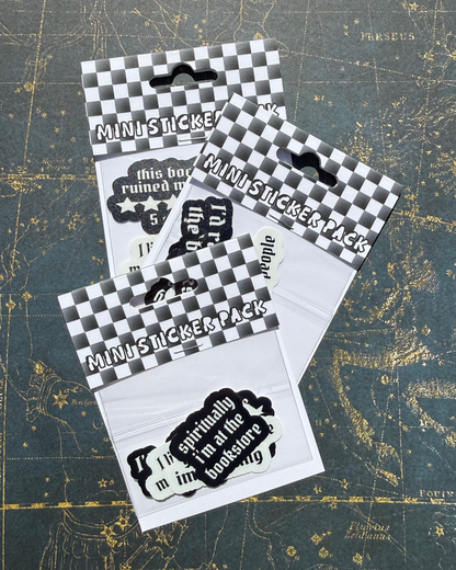 Packaged stickers with black and white designs on a textured surface