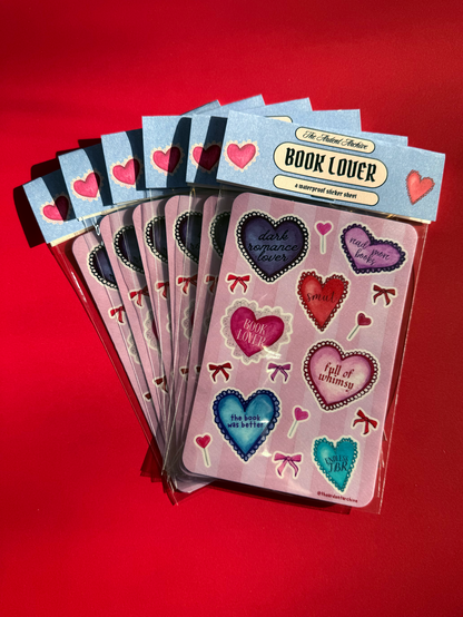 Set of packaged heart-themed book lovers stickers on a red background.
