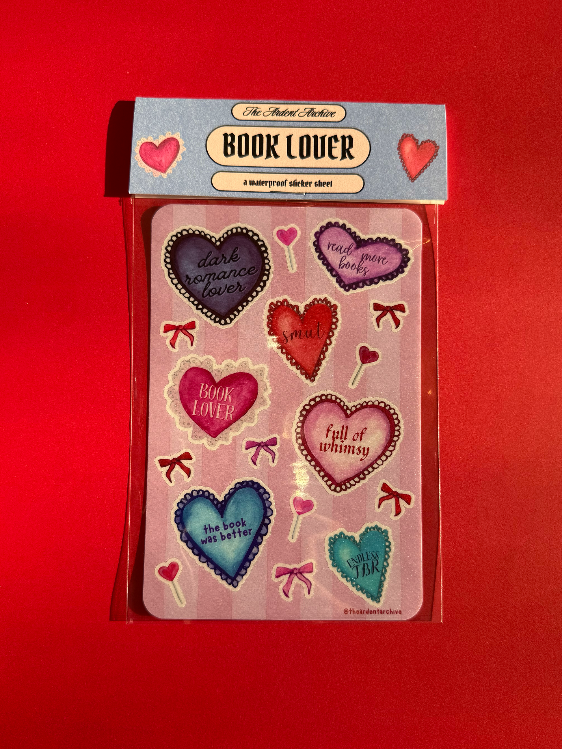Packaged sticker sheet with heart designs and 'Book Lover' branding on a red background.