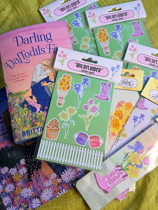 Collection of 'Wildflower' sticker sheets and a book titled 'Darling Daffodils' on a green surface.