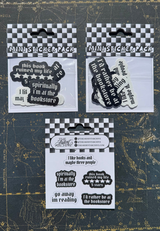Three packs of stickers with humorous text on a dark background