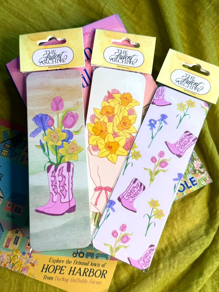 Set of bookmarks with floral and boot designs on a green fabric background