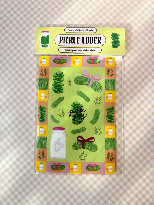 Packaged pickle-themed sticker sheet on a checkered background
