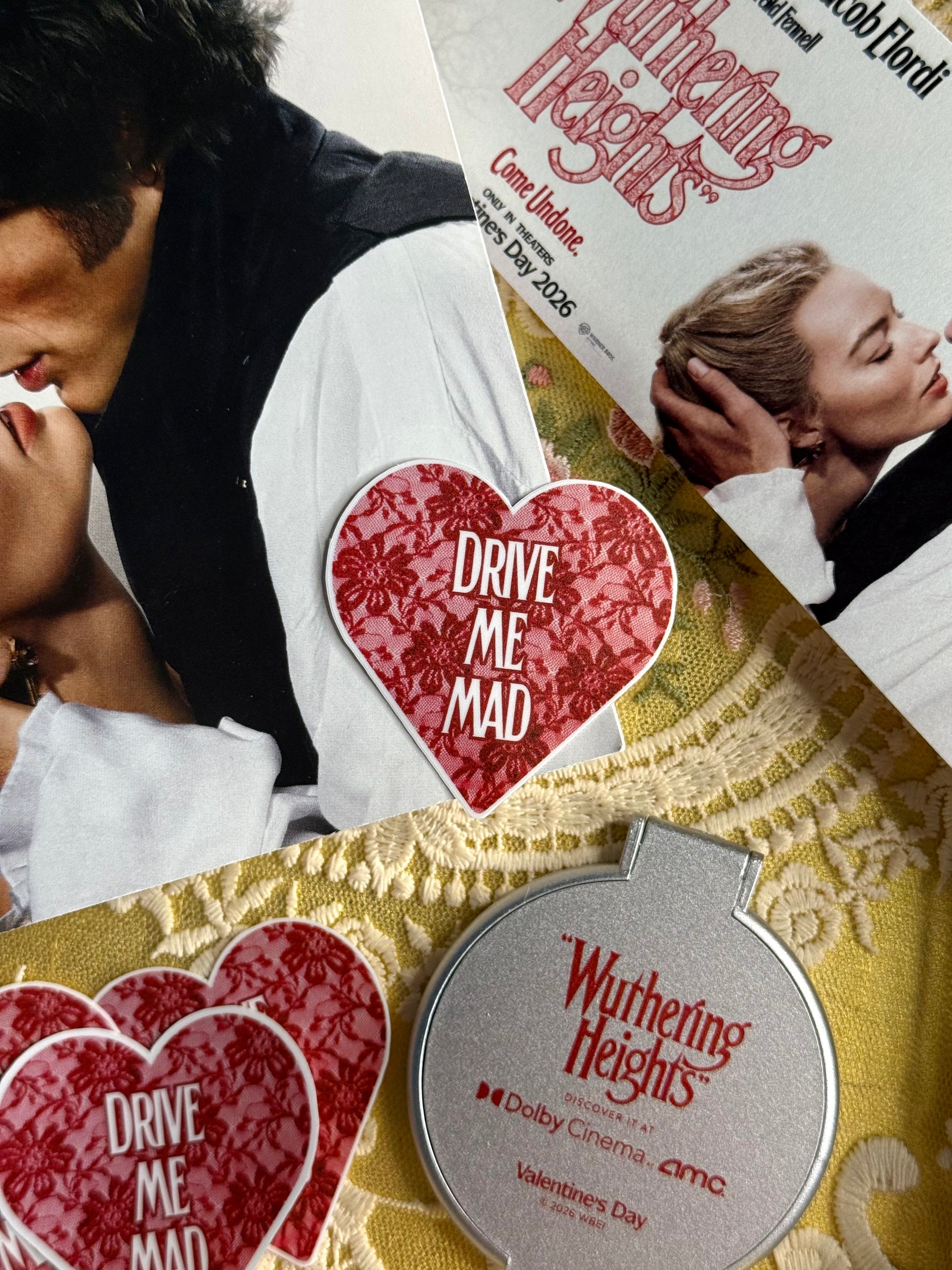 flat lay of 'Wuthering Heights' movie ticket, heart-shaped 'Drive Me Mad' cards, and book