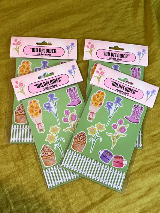Sticker sheets with 'Wildflower' branding on a yellow surface