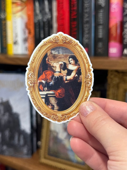 Hand holding a decorative sticker with classical painting design in front of a bookshelf.