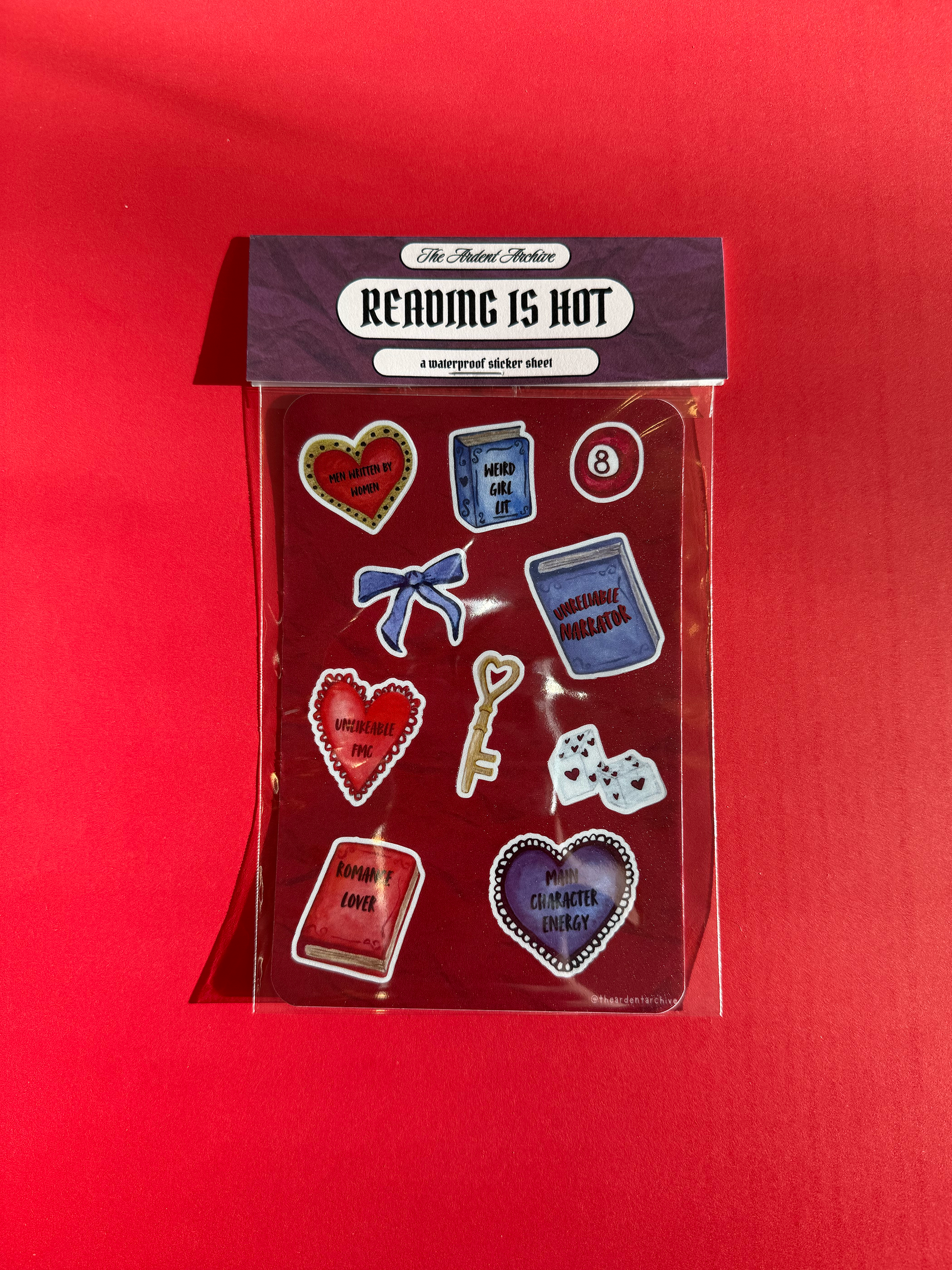 Packaged red sticker sheet with books, hearts, keys, and bow designs on a red background. Watercolor style. 